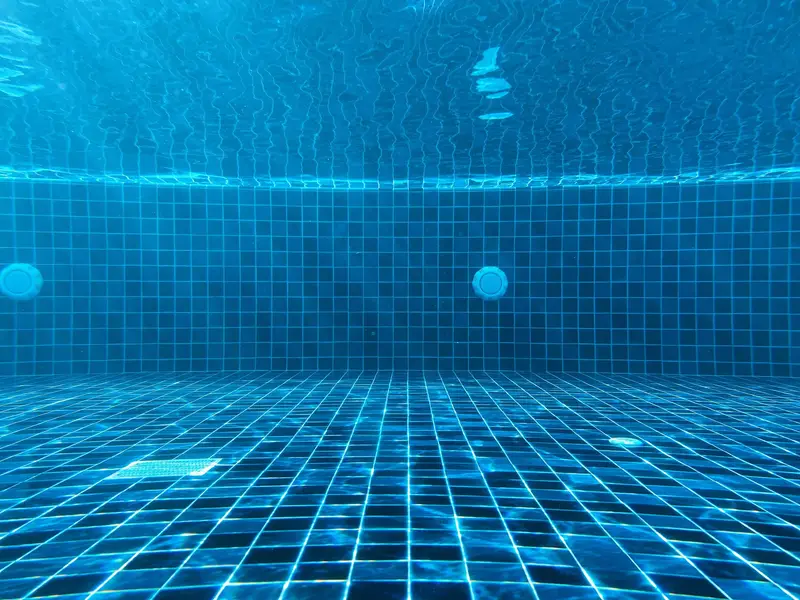 Underwater view of a clean pool floor drain and return jets