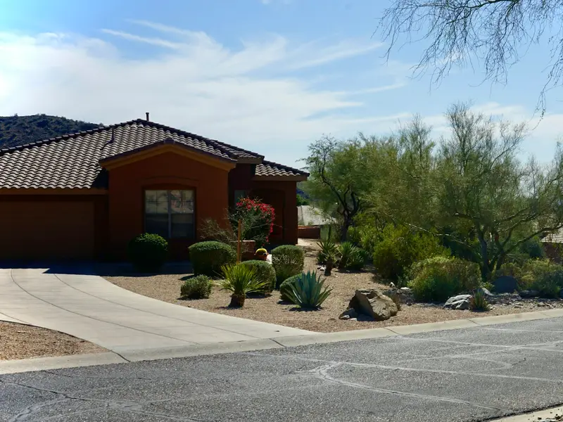 Arizona home with a desert front yard of gravel, agave and boulders